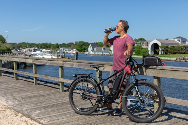 Man pausing to drink while riding an e-bike